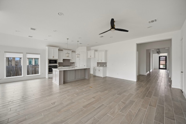 unfurnished living room featuring light hardwood / wood-style flooring and ceiling fan