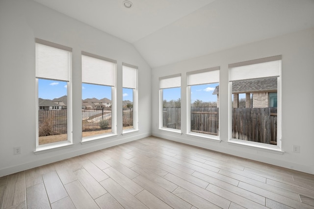 unfurnished sunroom featuring vaulted ceiling