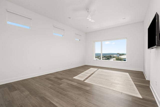 empty room with ceiling fan and dark hardwood / wood-style floors