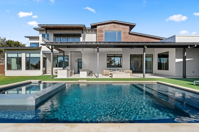 rear view of house featuring a pool with hot tub, a patio, and a balcony