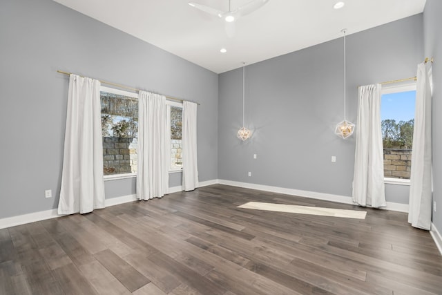 spare room with dark hardwood / wood-style floors, a healthy amount of sunlight, and ceiling fan