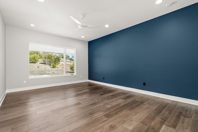 empty room with hardwood / wood-style floors and ceiling fan