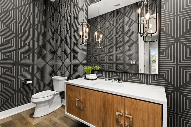 bathroom with vanity, toilet, and hardwood / wood-style floors