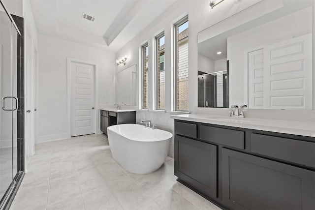 bathroom with tile patterned floors, vanity, a tray ceiling, and independent shower and bath