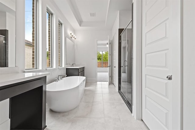 bathroom with vanity, a tray ceiling, independent shower and bath, and tile patterned flooring