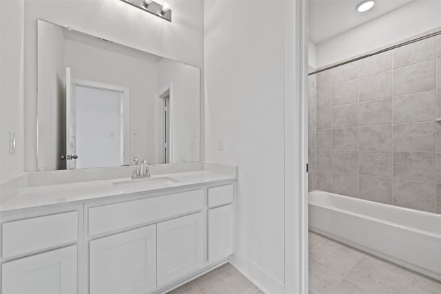 bathroom featuring tiled shower / bath, vanity, and tile patterned flooring