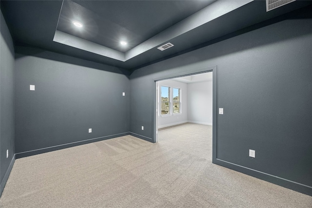 empty room featuring baseboards, carpet flooring, visible vents, and a raised ceiling