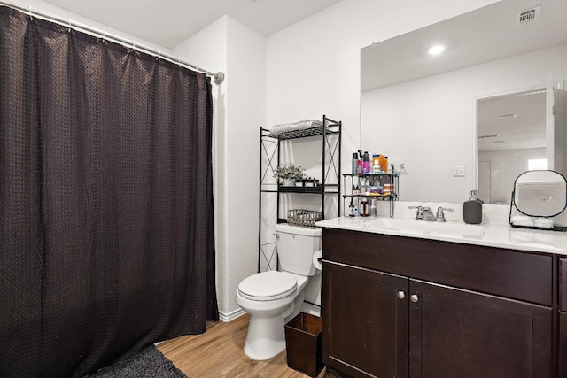 bathroom featuring wood-type flooring, vanity, and toilet