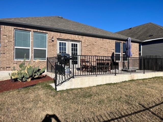 rear view of property featuring french doors, a yard, and a patio