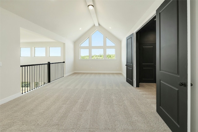 additional living space featuring high vaulted ceiling, baseboards, beam ceiling, and light colored carpet