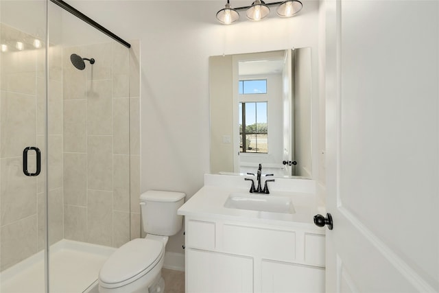 bathroom with toilet, a shower stall, and vanity