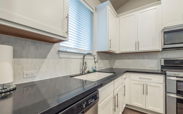 1905 Standing Tall Dr Unit 40, Leander, TX 78641 - kitchen with appliances with stainless steel finishes, decorative backsplash, white cabinetry, dark stone counters, and vaulted ceiling