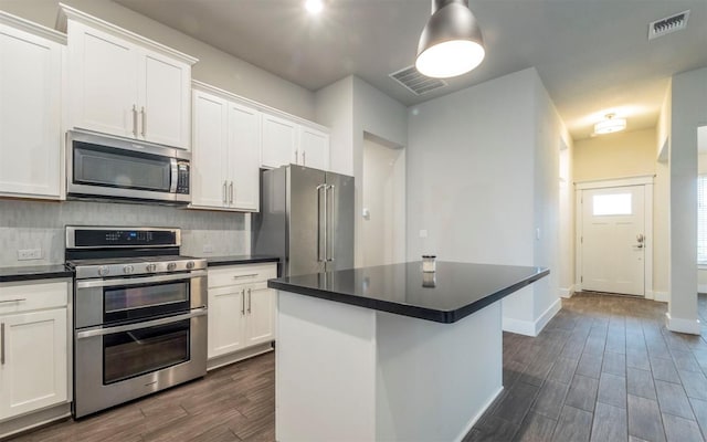 1905 Standing Tall Dr Unit 40, Leander, TX 78641 - kitchen featuring appliances with stainless steel finishes, dark wood-style flooring, dark countertops, decorative backsplash, and white cabinets