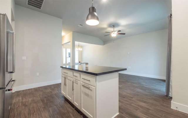 kitchen featuring white cabinetry, stainless steel fridge, dark hardwood / wood-style flooring, and hanging light fixtures