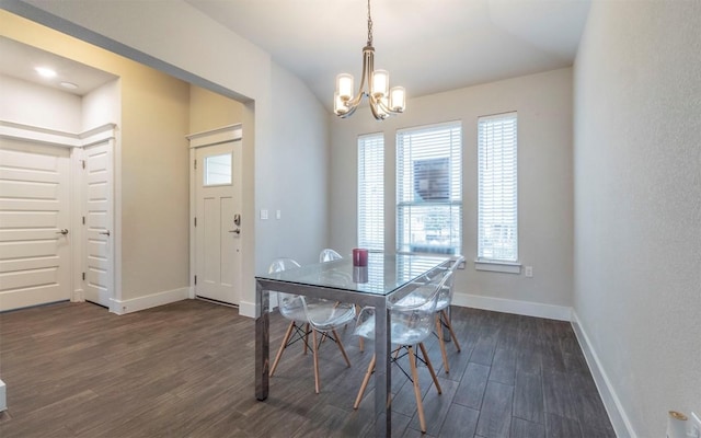 dining area with dark hardwood / wood-style flooring and an inviting chandelier