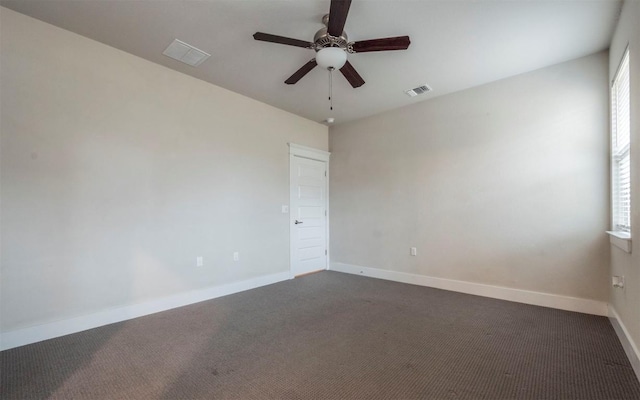 spare room with dark carpet and ceiling fan