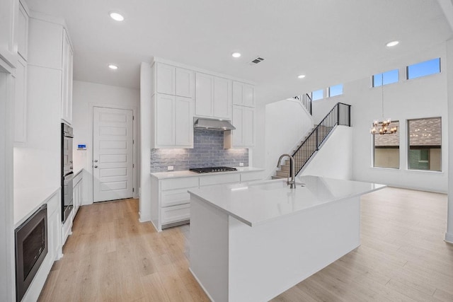 228 Running Fawn, Georgetown, TX 78628 - kitchen with appliances with stainless steel finishes, tasteful backsplash, light wood finished floors, light countertops, and white cabinets