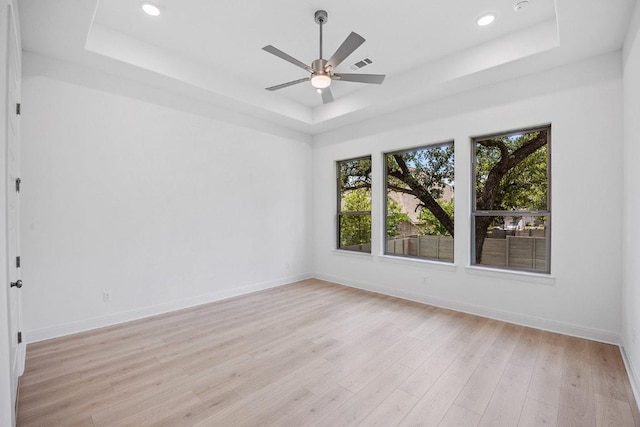 228 Running Fawn, Georgetown, TX 78628 - unfurnished room featuring a tray ceiling, light wood-type flooring, a ceiling fan, and recessed lighting