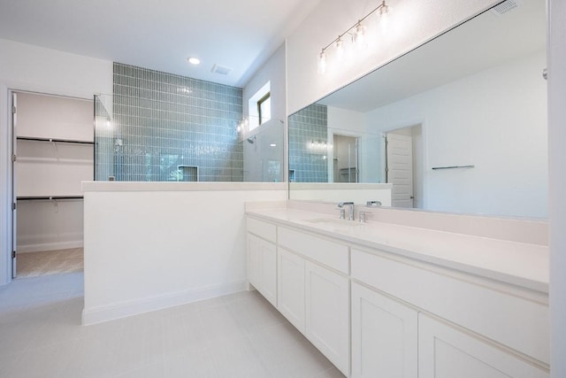 228 Running Fawn, Georgetown, TX 78628 - full bathroom featuring walk in shower, vanity, a spacious closet, and tile patterned floors