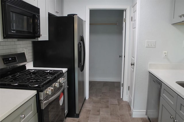 kitchen with tasteful backsplash, stainless steel appliances, and gray cabinets