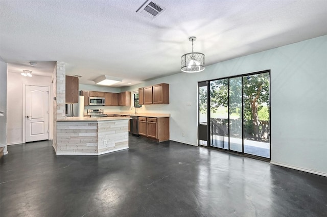 kitchen with sink, hanging light fixtures, a textured ceiling, appliances with stainless steel finishes, and a notable chandelier