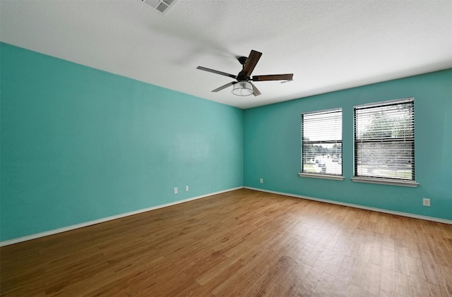 spare room featuring wood-type flooring and ceiling fan