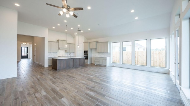 228 La Venta Loop, Liberty Hill, TX 78642 - kitchen featuring a center island with sink, open floor plan, backsplash, recessed lighting, and a ceiling fan