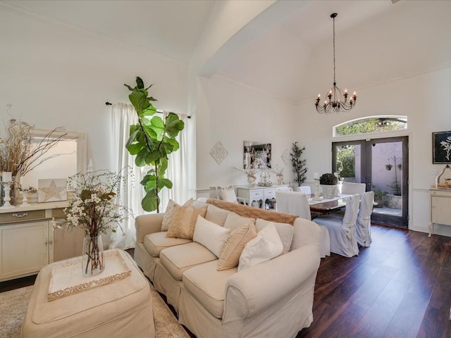 living room with dark wood-type flooring, a notable chandelier, high vaulted ceiling, and french doors