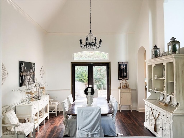 dining space with dark wood-type flooring, an inviting chandelier, high vaulted ceiling, and french doors