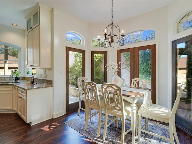 dining area featuring sink, a chandelier, dark hardwood / wood-style flooring, and french doors