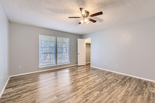 empty room featuring hardwood / wood-style flooring, ceiling fan, and a textured ceiling