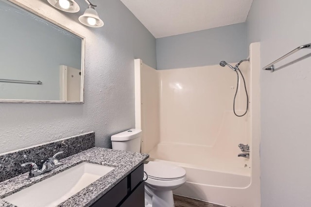 full bathroom with vanity, hardwood / wood-style flooring, toilet, and washtub / shower combination