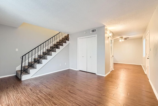 interior space with wood-type flooring, ceiling fan, and a textured ceiling