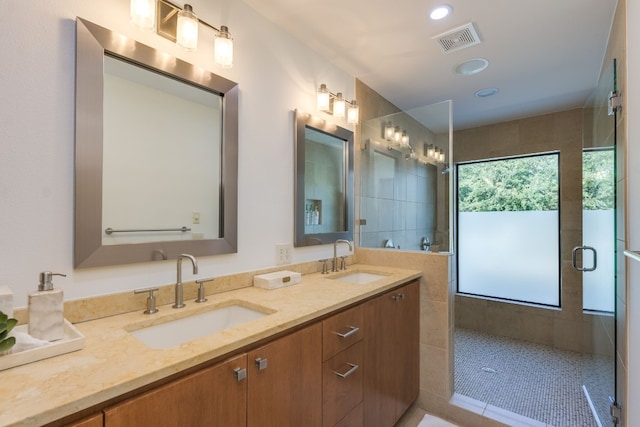 bathroom featuring tile patterned flooring, vanity, and tiled shower