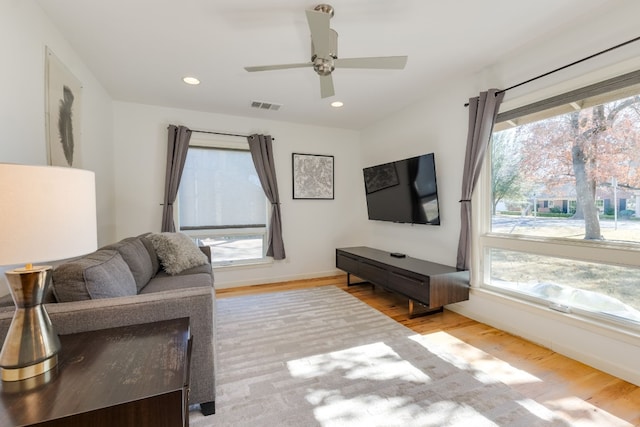 living room with light hardwood / wood-style floors and ceiling fan