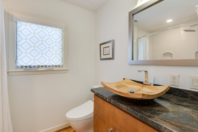 bathroom featuring vanity, toilet, and walk in shower