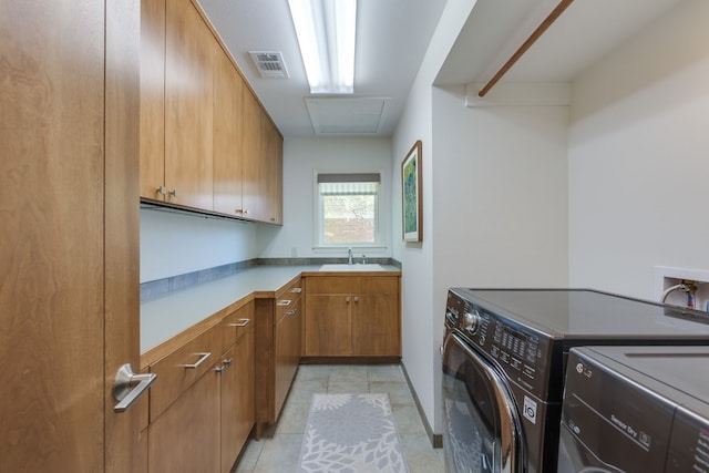 laundry room with sink, washer and clothes dryer, and cabinets