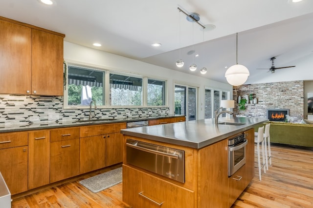 kitchen featuring decorative backsplash, sink, oven, and decorative light fixtures