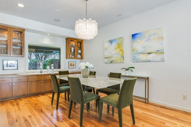 dining area with a chandelier and light hardwood / wood-style flooring