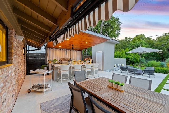 patio terrace at dusk with a bar and an outdoor hangout area