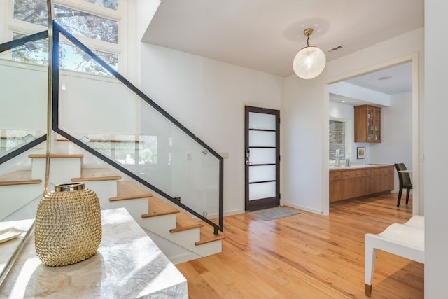 staircase featuring sink and hardwood / wood-style floors