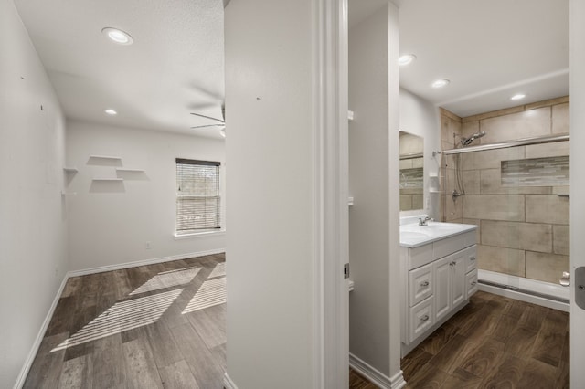 bathroom featuring hardwood / wood-style flooring, vanity, ceiling fan, and walk in shower