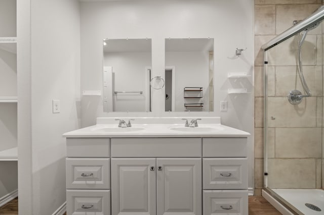 bathroom with an enclosed shower, vanity, and wood-type flooring