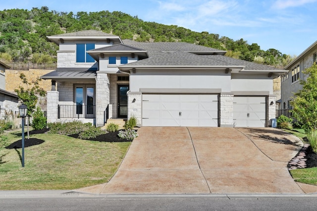 prairie-style house with a garage and a front lawn