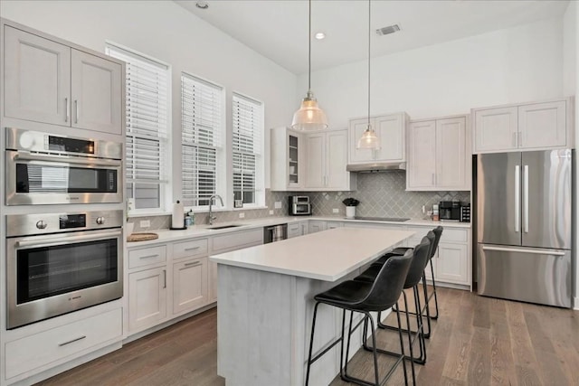 kitchen featuring white cabinetry, sink, stainless steel appliances, and a center island