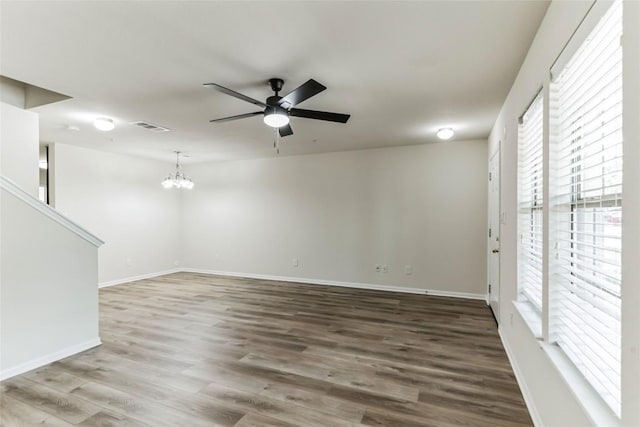 unfurnished room featuring hardwood / wood-style floors and ceiling fan with notable chandelier