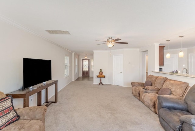 carpeted living room featuring crown molding and ceiling fan