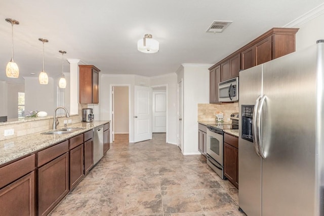 kitchen featuring sink, light stone counters, crown molding, decorative light fixtures, and appliances with stainless steel finishes