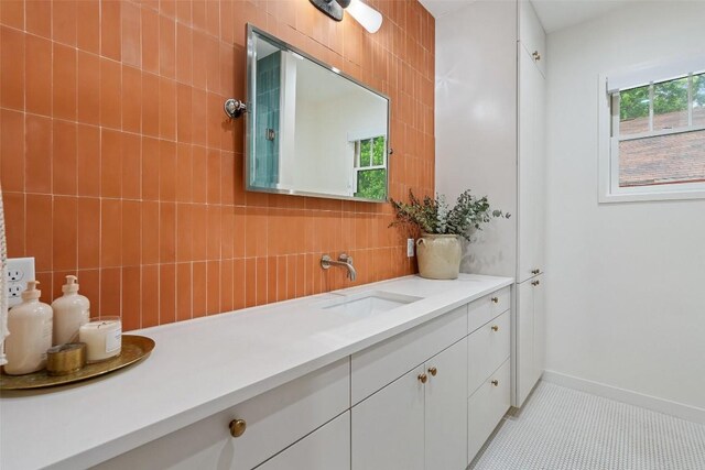 bathroom with vanity, a wealth of natural light, tile patterned floors, and tile walls