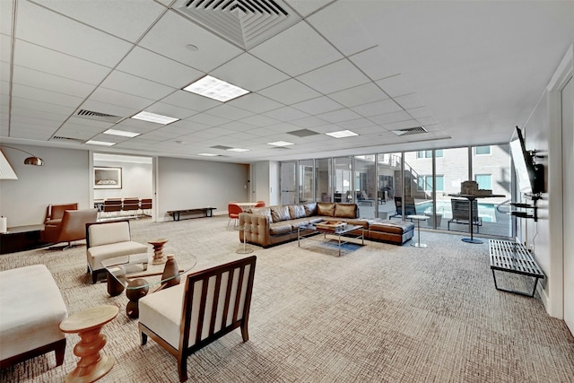 living room with a paneled ceiling, floor to ceiling windows, and carpet flooring